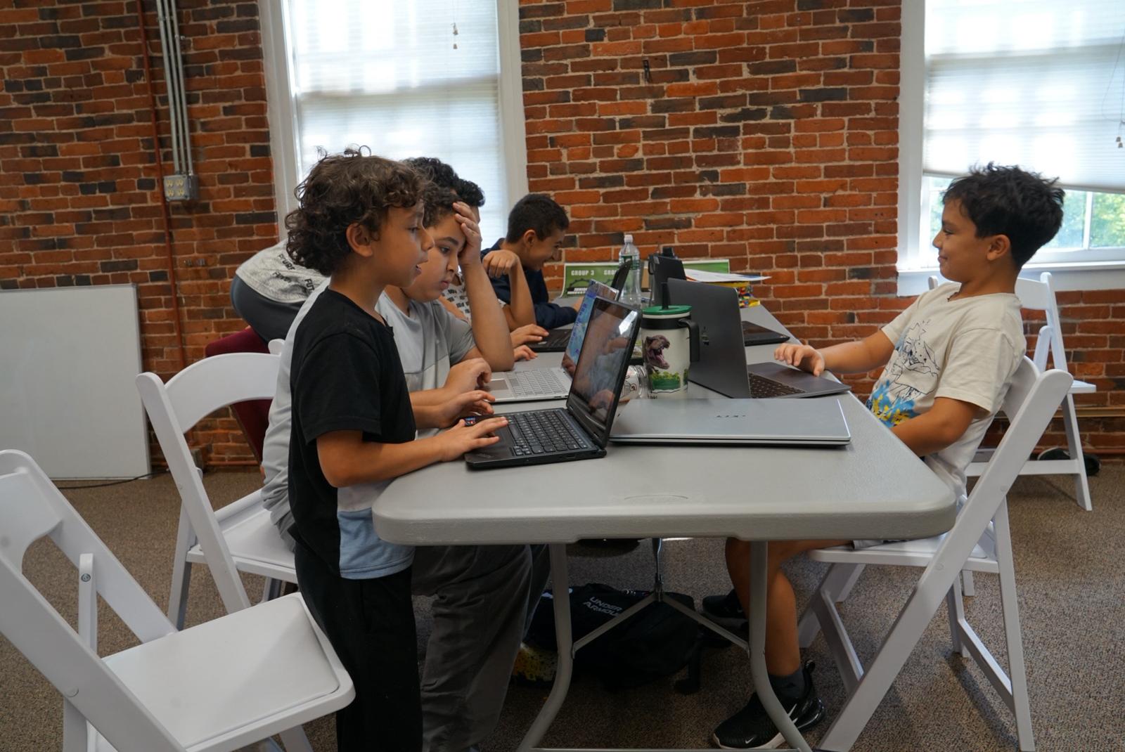 Students learning to code on laptops